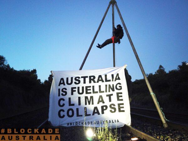 Blockade Australia activist suspended from a tripod blocking trains near Port of Newcastle, Australia, on Nov. 14, 2021. (Blockade Australia)