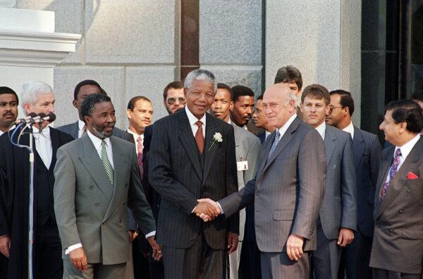 Elected South African President Nelson Mandela (C) and former President and Deputy President Frederick De Klerk (R) shake hands as Second Deputy President Thabo Mbeki (L) looks on, after the inaugural sitting of South Africa’s first all-race parliament in Cape Town, South Africa, on May 9, 1994. (Alexander Joe/AFP via Getty Images)