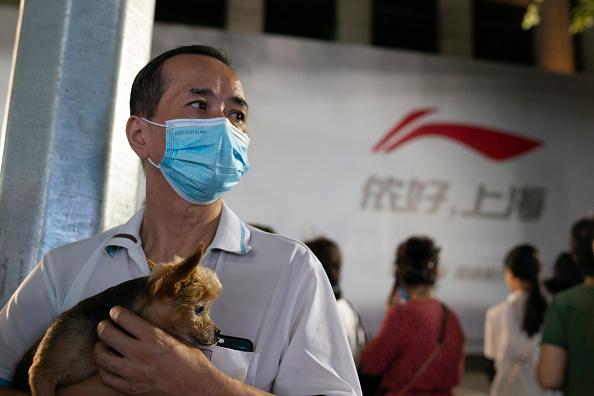 A man holds a dog on September 11, 2021 in Shanghai, China. (Hu Chengwei/Getty Images)