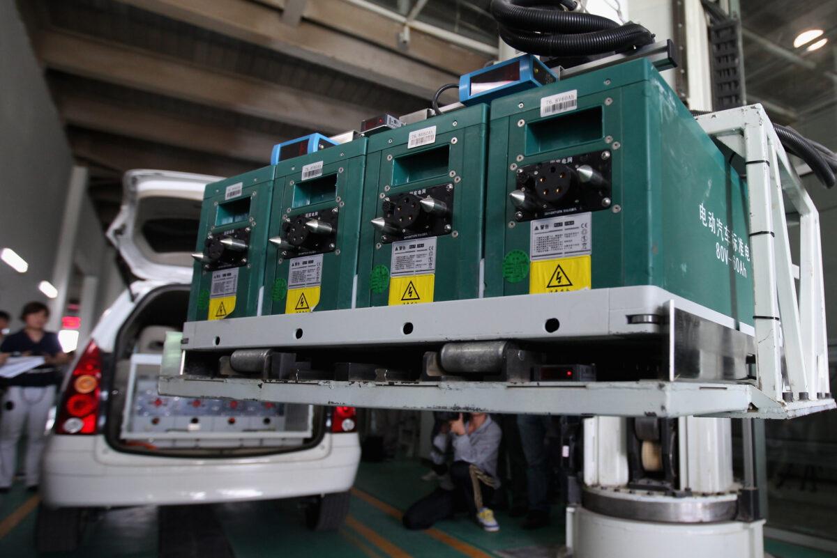 A battery exchange robot changes the batteries to an electric car at China's largest electric vehicle battery recharging station in Beijing on May 30, 2012. (Feng Li/Getty Images)