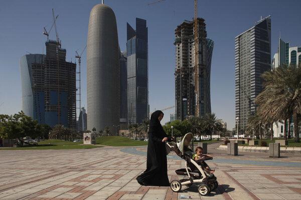 A woman pushes a stroller near new office skyscrapers in the budding new financial district in Doha, Qatar, on Oct. 23, 2011. (Sean Gallup/Getty Images)