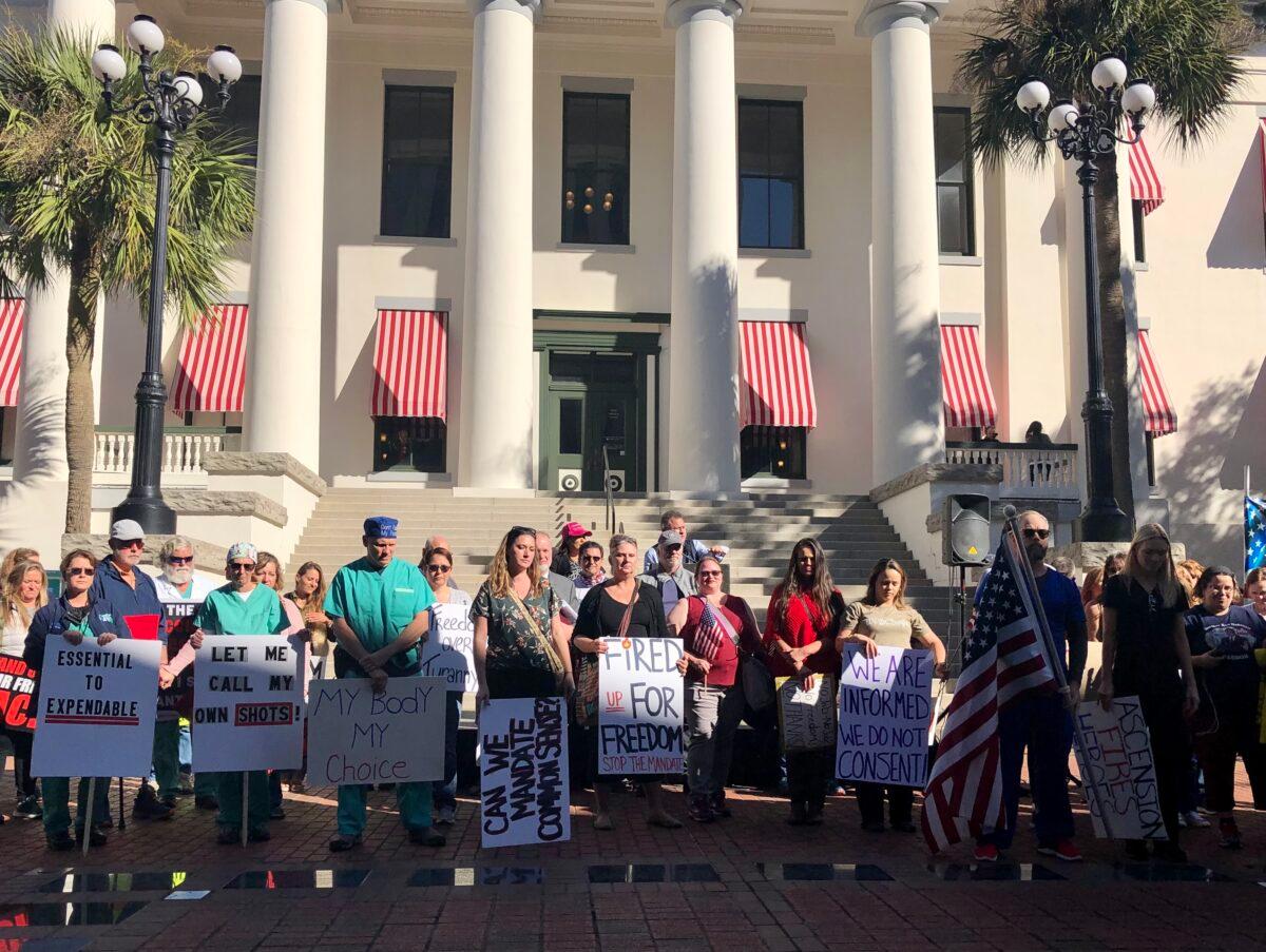 People stand in a courtyard outside the Florida Capitol to urge lawmakers to pass bills against mask and vaccine mandates, in Tallahassee, Florida, on Nov. 16, 2021. (Nanette Holt for The Epoch Times)