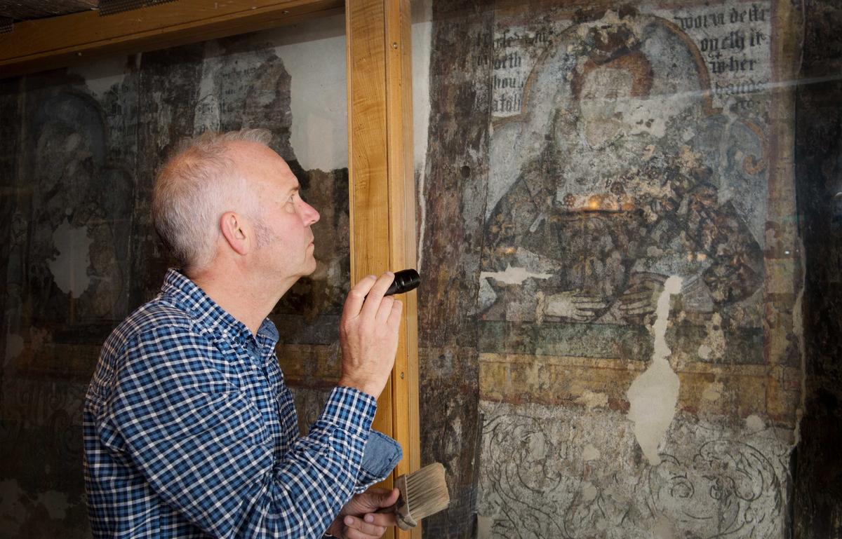 Conservator Mark Perry inspects a portrait of a woman previously thought to be Queen Elizabeth I. (Courtesy of Weatherspoons)