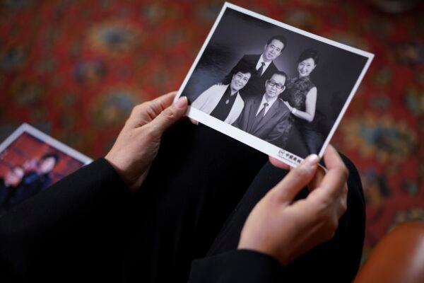 Grace Meng, the wife of former Interpol president Meng Hongwei, shows photos of her parents, first row, and her with her husband, as she answers the Associated Press in Lyon, central France, on Nov. 16, 2021. (Laurent Cipriani/AP Photo)