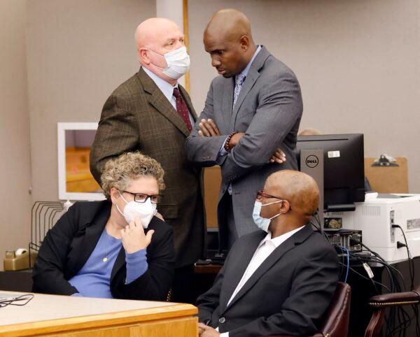 Defense attorney Kobby Warren, (standing R), listens to attorney Mark Watson (top L), as his client Billy Chemirmir (seated R), waits for motions and language being sent to the jury in his capital murder trial at the Frank Crowley Courts Building in Dallas, on Nov. 19, 2021. (Tom Fox/The Dallas Morning News via AP)