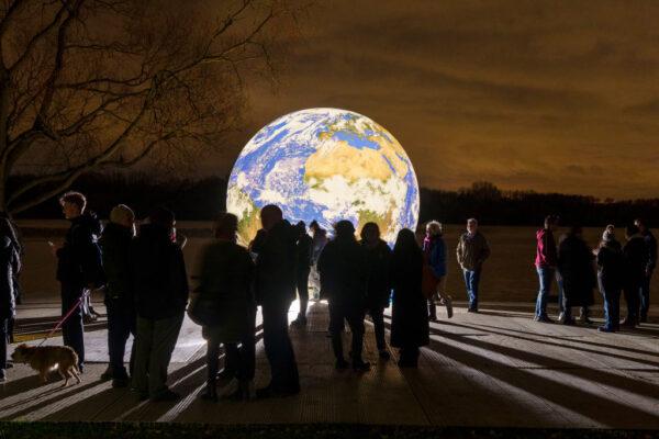 People view artist Luke Jerram’s new ‘Floating Earth’ Debuts In Wigan, England, on Nov. 18, 2021. (Christopher Furlong/Getty Images)