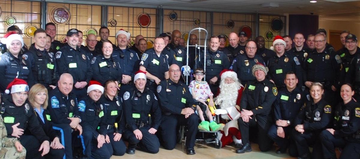 Josh and police officers just before Christmas at the children’s hospital of Pittsburgh. Every year, the police bring plenty of toys and pass them out to all the children. (Courtesy of <a href="https://www.facebook.com/rebecca.bourassa.3">Rebecca Bourassa</a>)