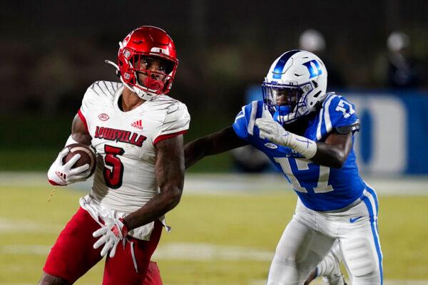 Louisville wide receiver Shai Werts (5) runs the ball while Duke safety Da'Quan Johnson (17) reaches in to tackle during the first half of an NCAA college football game in Durham, N.C., on Nov. 18, 2021. (Gerry Broome/AP Photo)