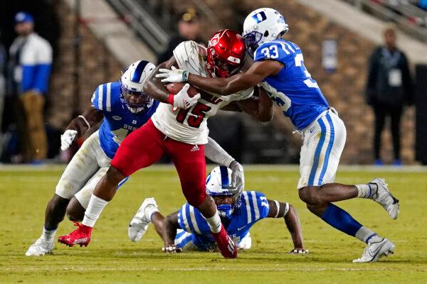 Louisville running back Jalen Mitchell (15) runs the ball while Duke cornerback Leonard Johnson (33) and linebacker Shaka Heyward move in to tackle during the first half of an NCAA college football game in Durham, N.C., on Nov. 18, 2021. (Gerry Broome/AP Photo)