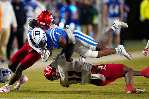 Duke wide receiver Jontavis Robertson (1) is tackled by Louisville defensive back Qwynnterrio Cole (12) and defensive back Chandler Jones during the second half of an NCAA college football game in Durham, N.C., on Nov. 18, 2021. (Gerry Broome/AP Photo)