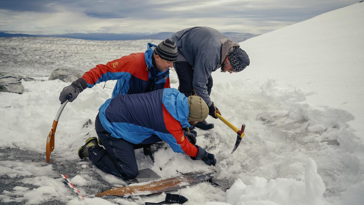 The ice covering the ski is chipped away with an ice axe. (Courtesy of <a href="https://secretsoftheice.com/">Andreas Christoffer Nilsson, secretsoftheice.com</a>)