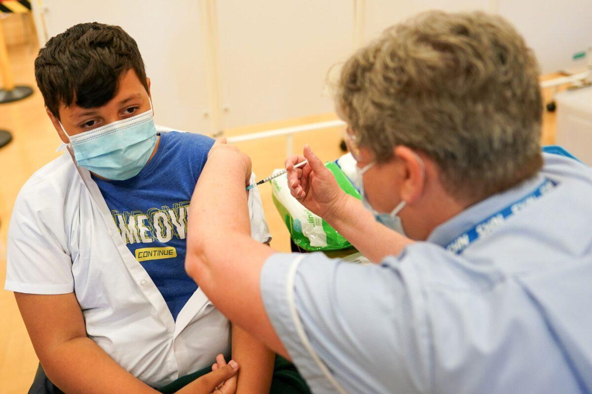 Felix Dima, 13, from Newcastle receives the Pfizer-BioNTech COVID-19 vaccine at the Excelsior Academy in Newcastle upon Tyne, England on Sept. 22, 2021. (Ian Forsyth/Getty Images)
