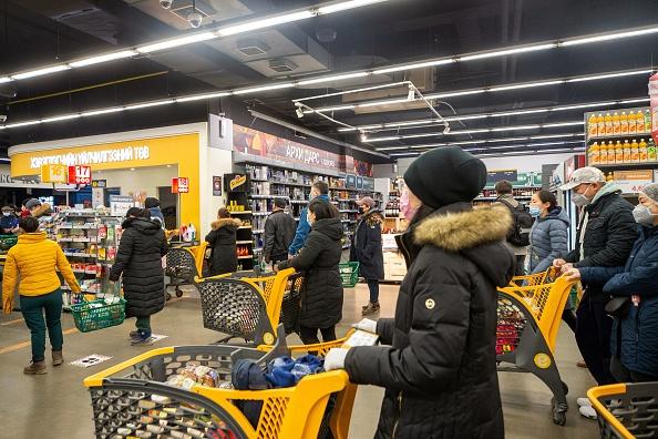 Customers wearing facemasks and socially distancing as a precaution against the COVID-19 coronavirus queue before checking out at the cashiers at a supermarket in Ulaanbaatar, the capital of Mongolia, on Nov. 13, 2020. (Byambasuren Byamba-Ochir/AFP via Getty Images)
