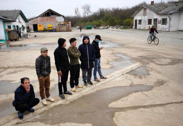 Vietnamese workers who are helping construct the first Chinese car tire factory in Europe stand in front of a barrack near the northern Serbian town of Zrenjanin, 50 kilometers north of Belgrade, Serbia, on Nov. 18, 2021. (Darko Vojinovic/AP Photo)