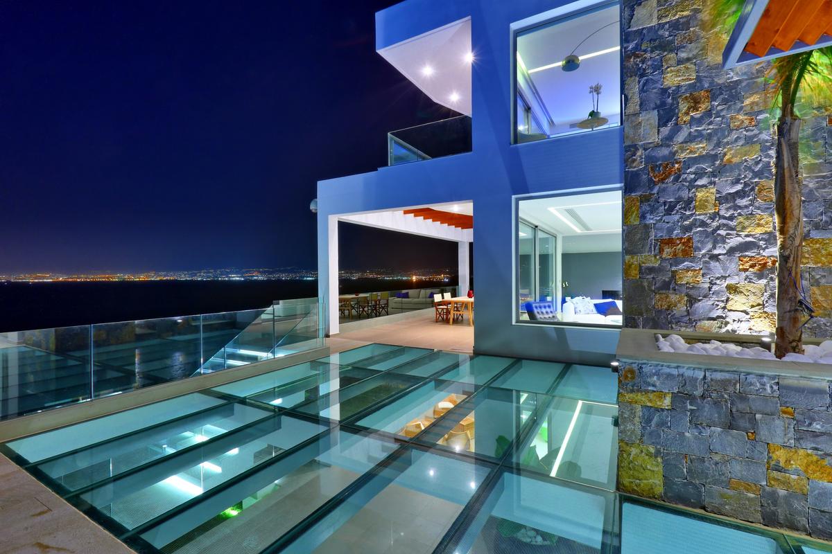 Night brings out another brilliant facet of the design of this property. The city lights reflecting off the bay, the crisp illumination, and the reflective transparency of the glass keep colors alive. (Pantelis Mathioudakis)