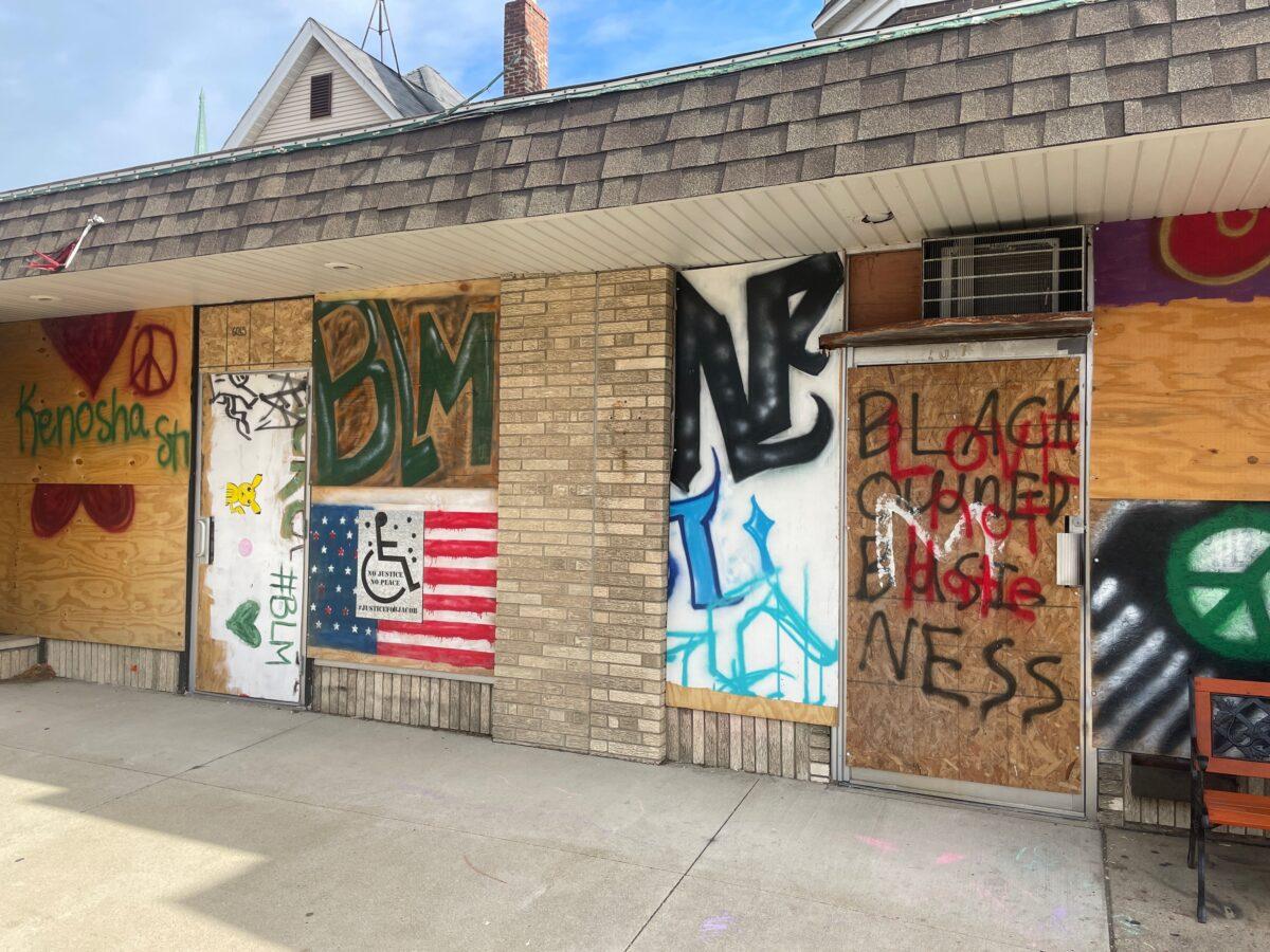 A patchwork of reused plywood protects a business in Kenosha, Wis., on Nov. 21, 2021. (Jackson Elliott/The Epoch Times)