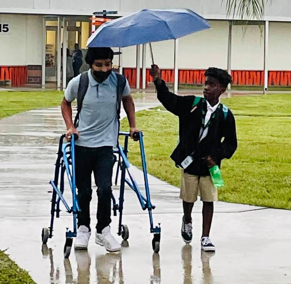 Lamar protecting Jerry from the rain with his umbrella. (Courtesy of Tina Kelley)