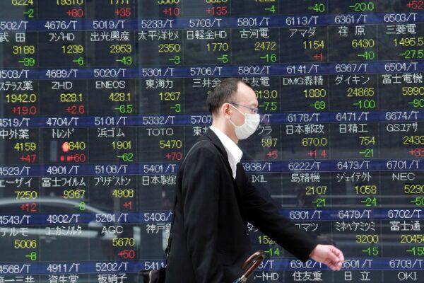 A man walks by an electronic stock board of a securities firm in Tokyo, Japan on Nov. 22, 2021. (Koji Sasahara/AP Photo)