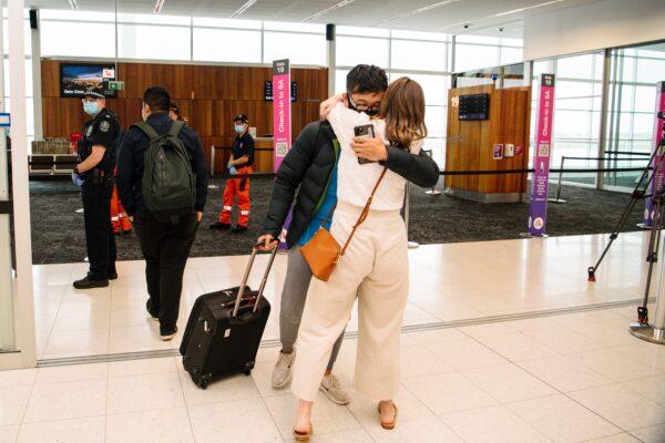 Young couple Hung Nguyen and Isabella Hill are reunited after a year after a flight from Sydney arrives this morning in Adelaide, Tuesday, November 23, 2021. (AAP Image/Morgan Sette)
