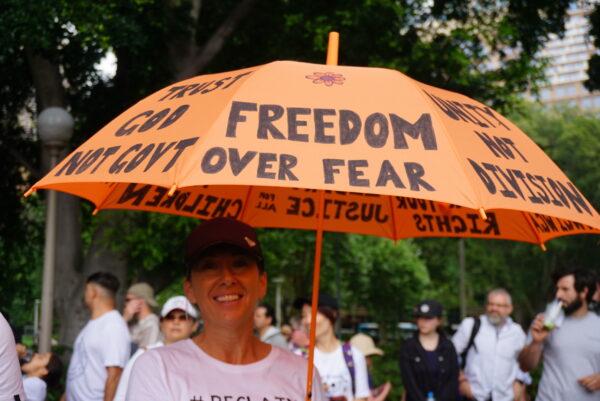 Protestor holding an umbrella saying “Freedom Over Fear” in Sydney, Australia, on Nov. 20, 2021. (Nina Nguyen/ Epoch Times)
