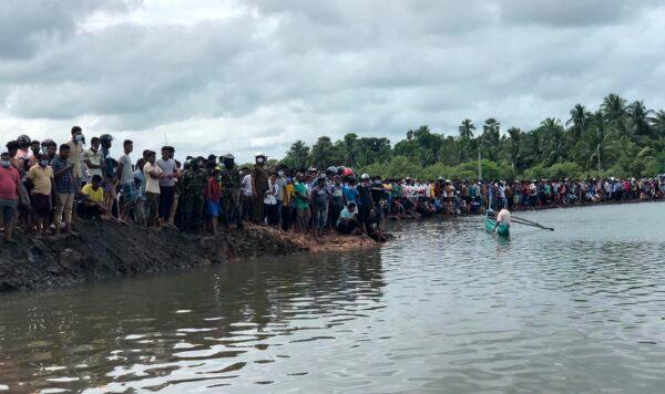 Sri Lankans watch rescue work following a ferry capsized in Kinniya, about 267 kilometers east of Colombo, Sri Lanka on Nov. 23, 2021. (Mangalanath Liyanaarachchi/AP Photo)