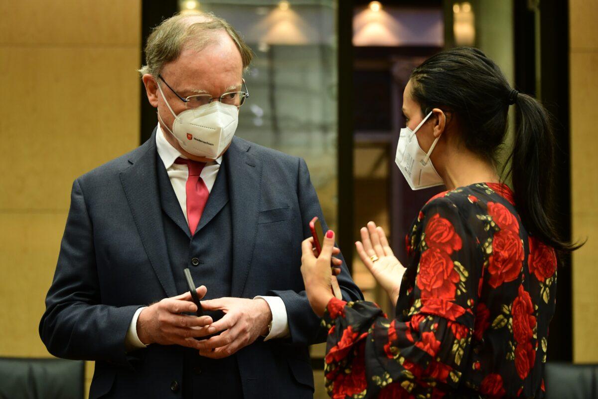 Lower Saxony State Premier Stephan Weil (L) and Berlin state secretary Sawsan Chebli wear face masks as they talk prior the 1000th session of the German Federal Council (Bundesrat), in Berlin, Germany, on Feb. 12, 2021. (Clemens Bilan/Pool/Getty Images)