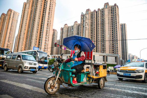 A vendor cycles through the Evergrande Changqing community in the rain in Wuhan, Hubei Province, China, on Sept. 24, 2021. ( Getty Images)
