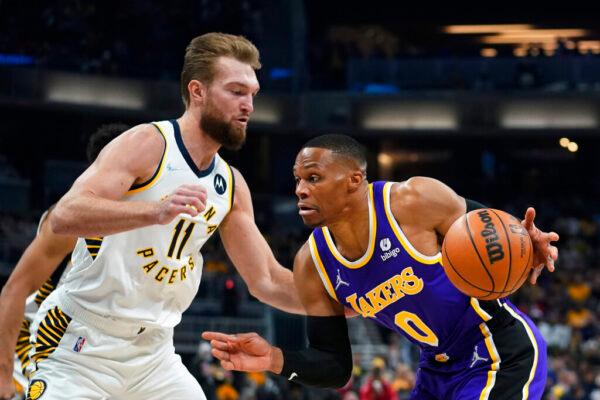 Los Angeles Lakers' Russell Westbrook (0) goes to the basket against Indiana Pacers' Domantas Sabonis (11) during the first half of an NBA basketball game in Indianapolis, on Nov. 24, 2021. (Darron Cummings/AP Photo)