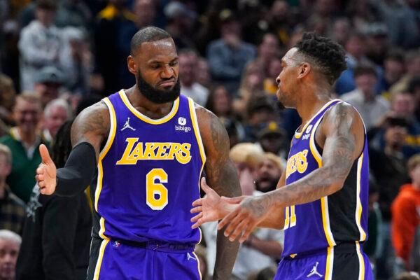 Los Angeles Lakers' LeBron James (6) celebrates with Malik Monk (11) during overtime of the team's NBA basketball game against the Indiana Pacers, in Indianapolis, on Nov. 24, 2021. (Darron Cummings/AP Photo)