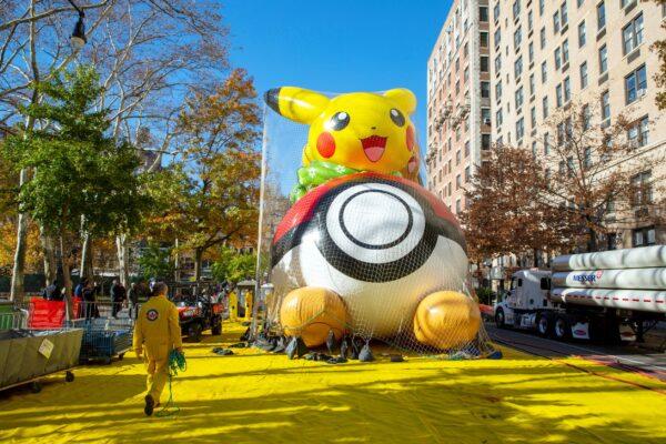 Crews pump helium into a balloon of Pikachu and Eevee as the balloon is readied for the Macy's Thanksgiving Day Parade the next day, in New York on Nov. 24, 2021. (Ted Shaffrey/AP Photo)