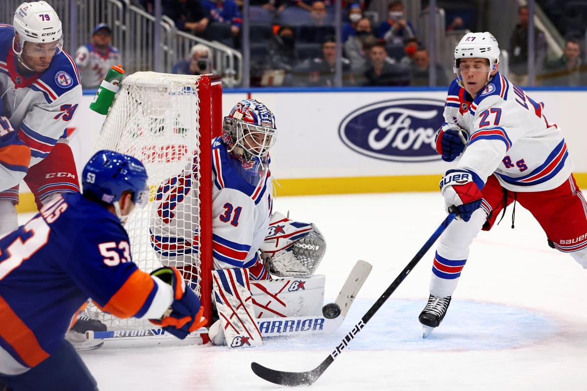 New York Rangers goaltender Igor Shesterkin (31) keeps his eye on the puck off a shot by New York Islanders center Casey Cizikas (53) as Rangers defensemen K'Andre Miller (79) and Nils Lundkvist (27) assist during the second period of an NHL hockey game in Elmont, N.Y., on Nov. 24, 2021. (Rich Schultz/AP Photo)