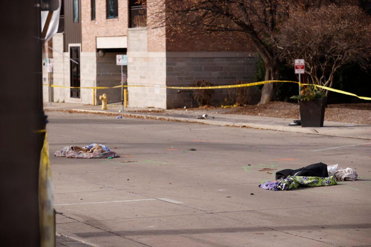 Items lie in the middle of a street in Waukesha, Wis., on Nov. 22, 2021, after a vehicle slammed into a holiday parade the day before killing several people and injuring multiple others. (Jeffrey Phelps/AP Photo)
