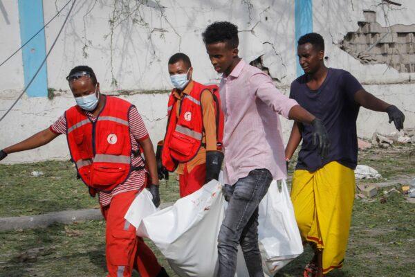 Rescue workers carry away the body of a civilian who was killed in a blast in Mogadishu, Somalia on Nov. 25, 2021. (Farah Abdi Warsameh/AP Photo)