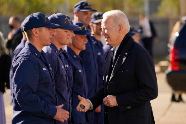 President Joe Biden hands out a challenge coin as he speaks with members of the Coast Guard at the United States Coast Guard Station Brant Point in Nantucket, Mass., on Nov. 25, 2021. (Carolyn Kaster/AP Photo)