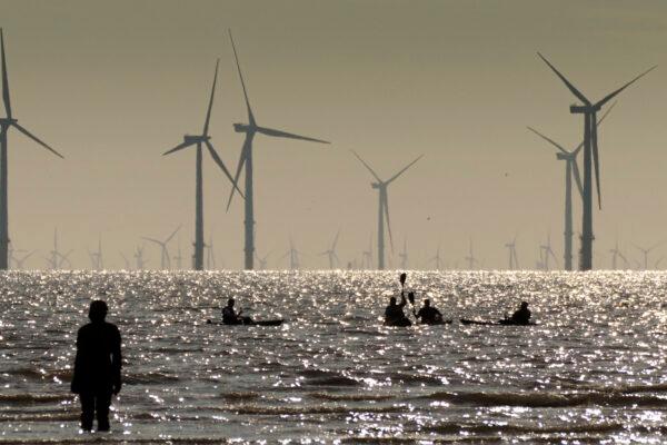 Kayakers paddle on the Mersey Estuary near the Burbo Bank Offshore Wind Farm in Liverpool, the United Kingdom, on Aug. 4, 2021. (Christopher Furlong/Getty Images)