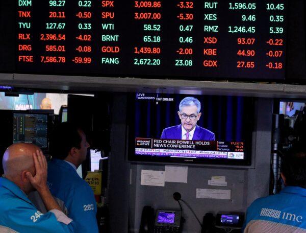Traders look on as a screen shows Federal Reserve Chairman Jerome Powell's news conference after the Federal Reserve interest rates announcement on the floor of the New York Stock Exchange (NYSE) in New York, on July 31, 2019. (Brendan McDermid/Reuters)