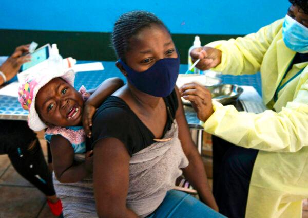 A mother receives her Pfizer vaccine against COVID-19 in Diepsloot Township near Johannesburg, on Oct. 21, 2021. (Denis Farrell/AP Photo)