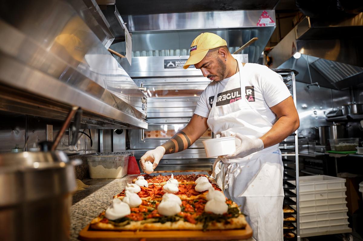 Salvatore Gagliardo, executive chef and partner, puts the finishing touches on the pizzas of the day in the Unregular Pizza kitchen. (Samira Bouaou/The Epoch Times)