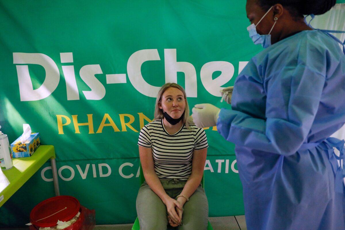 A health care worker prepares to conduct a COVID-19 test on a traveler at OR Tambo International Airport in Johannesburg, South Africa, on Nov. 27, 2021. (Phill Magakoe/AFP via Getty Images)