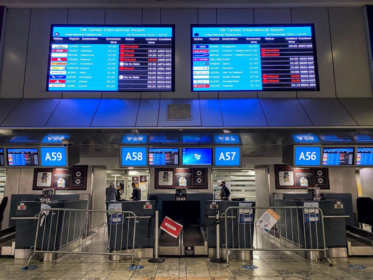Digital display boards show canceled flights to London Heathrow at O.R. Tambo International Airport in Johannesburg, on Nov. 26, 2021. (Sumaya Hisham/Reuters)