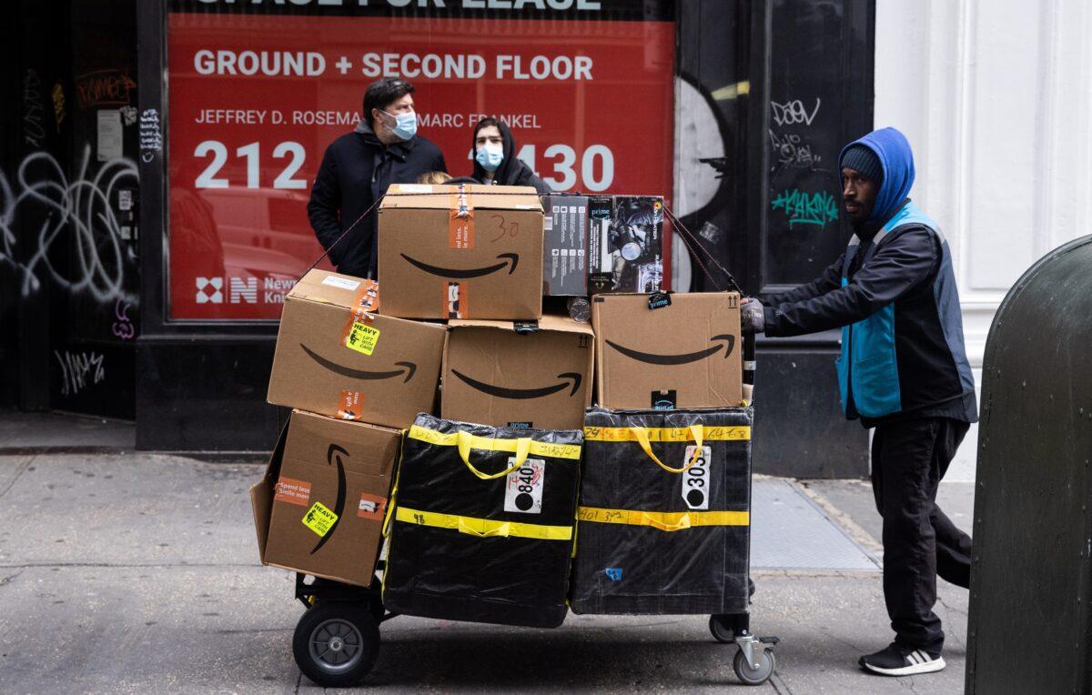 A delivery person pushes a cart full of Amazon boxes during Black Friday sales in the Manhattan borough of New York City, New York, on Nov. 26, 2021. (Jeenah Moon/Reuters)