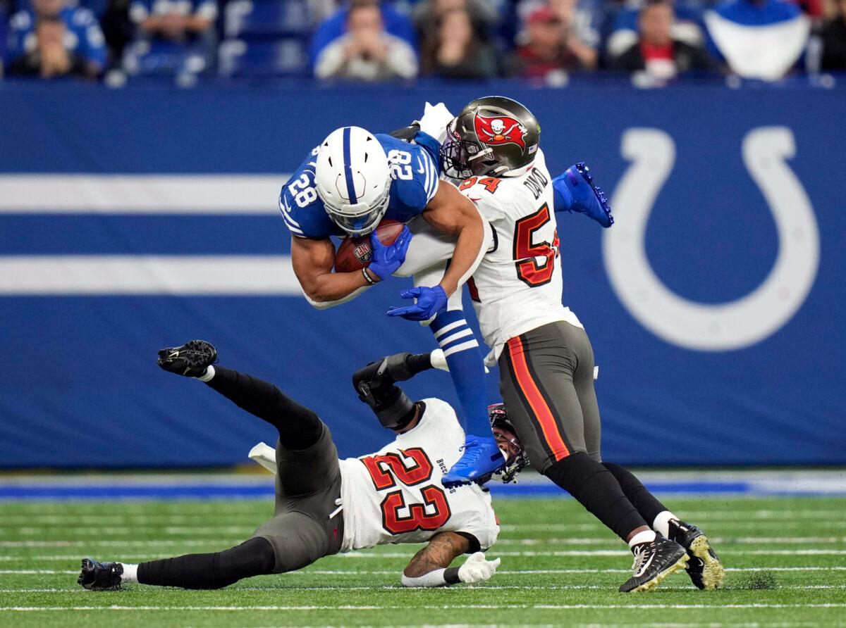 Indianapolis Colts' Jonathan Taylor (28) is tackled by Tampa Bay Buccaneers' Sean Murphy-Bunting (23) and Lavonte David (54) during the first half of an NFL football game, in Indianapolis, on Nov. 28, 2021. (AJ Mast/AP Photo)