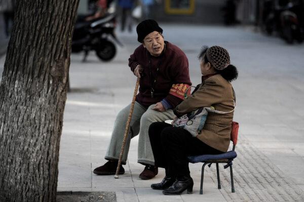 A volunteer (L) talks with a Chinese woman by the roadside in Beijing on November 1, 2012. (Wang Zhao/AFP via Getty Images)