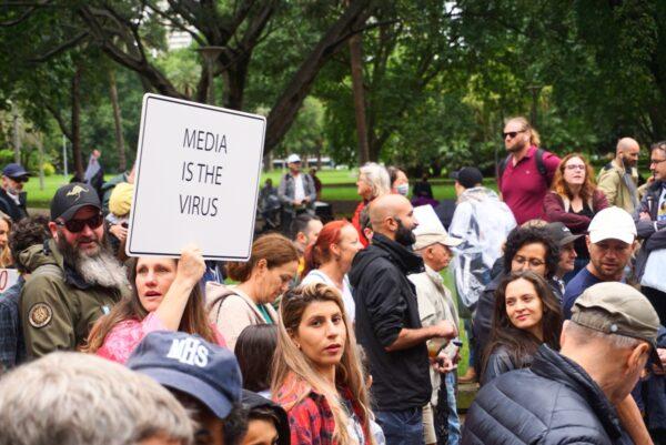 A protester held a sign saying "Media is the Virus" in Sydney, Australia, on Nov. 27, 2021. (Nina Nguyen/ Epoch Times)