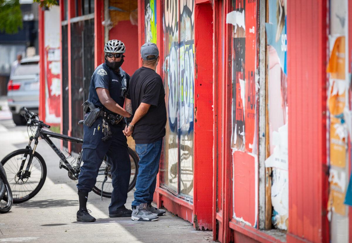 A man is arrested by an LAPD officer in Venice Beach, Calif., on June 2, 2020. (John Fredricks/The Epoch Times)