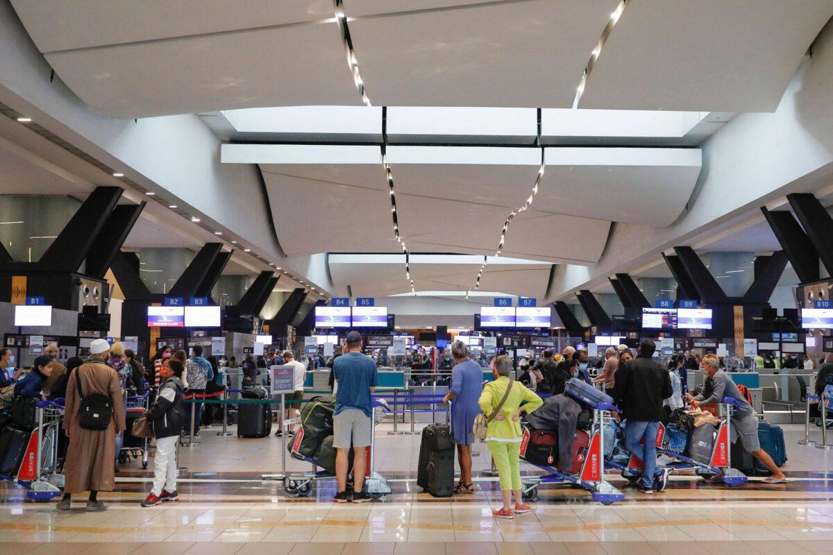 Travelers in line at a check-in counter at OR Tambo International Airport in Johannesburg on Nov. 27, 2021. (Phill Magakoe/AFP via Getty Images)