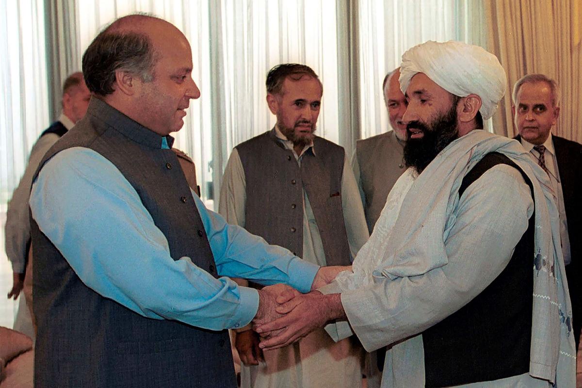 Mullah Hassan Akhund (R), then Afghanistan's Foreign Minister is received by then Pakistan Prime Minister Nawaz Sharif, in Islamabad, on Aug. 25, 1999. (B.K. Bangash/AP Photo)