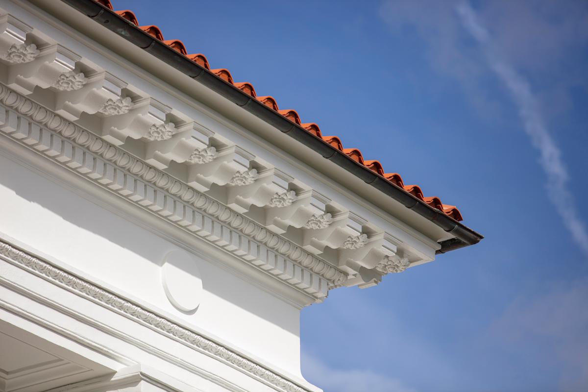 The architecture is detailed with a refined cornice. Rosettes can be seen between the curved corbels. The terracotta roof tiles enliven the white and green palette of the surrounding landscape. (Flagler Museum)