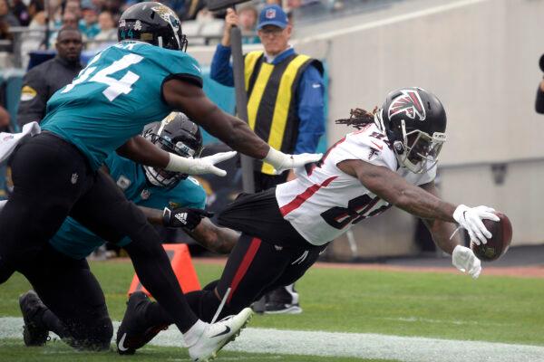 Atlanta Falcons running back Cordarrelle Patterson, right, dives for a touchdown past Jacksonville Jaguars linebacker Myles Jack (44) during the first half of an NFL football game in Jacksonville, Fla., on, Nov. 28, 2021. (Phelan M. Ebenhack/AP Photo)