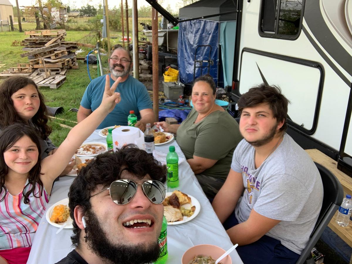 Hypolite Nazio and his family share a meal beside the trailer. (Courtesy of <a href="https://www.facebook.com/profile.php?id=100002074783051">Hypolite Nazio</a>)